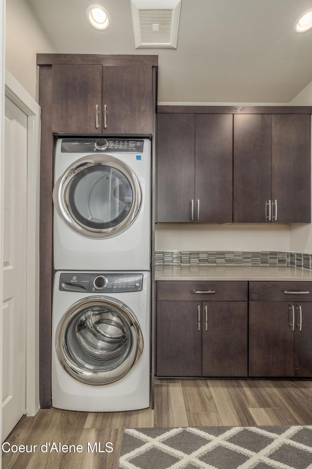 2999 N Casa Ct, Coeur Dalene, ID 83814 - laundry room with stacked washer / dryer, cabinet space, light wood finished floors, and recessed lighting