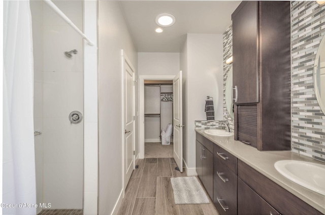 2999 N Casa Ct, Coeur Dalene, ID 83814 - full bathroom with double vanity, a shower, wood finished floors, a walk in closet, and recessed lighting