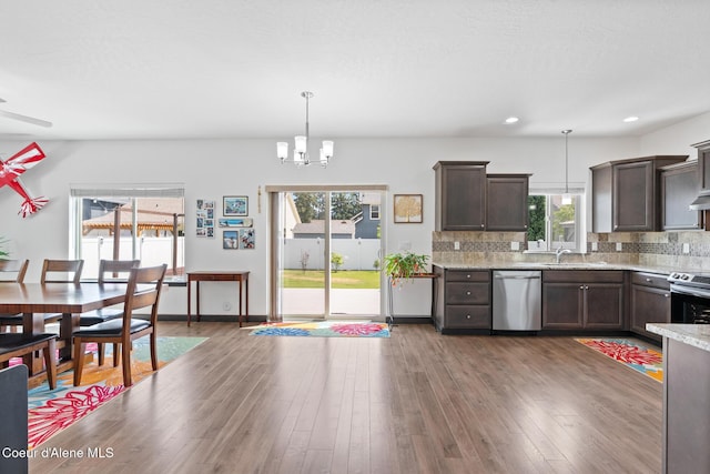 6522 N Idlewood Dr, Coeur Dalene, ID 83815 - kitchen with stainless steel appliances, dark brown cabinetry, decorative backsplash, a chandelier, and decorative light fixtures