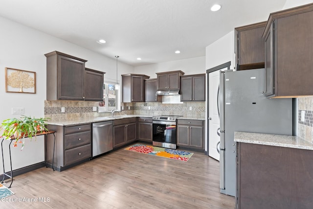 6522 N Idlewood Dr, Coeur Dalene, ID 83815 - kitchen with stainless steel appliances, under cabinet range hood, dark brown cabinets, light wood-type flooring, and recessed lighting