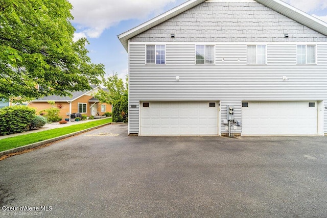931 N Goldenrod Ct, Post Falls, ID 83854 - back of house featuring an attached garage and asphalt driveway