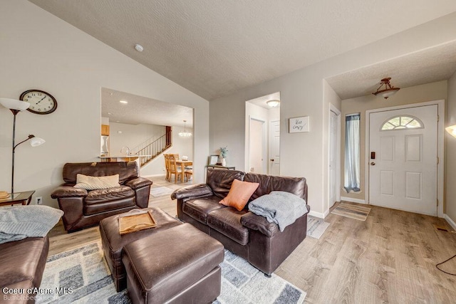 931 N Goldenrod Ct, Post Falls, ID 83854 - living room with light wood-style floors, vaulted ceiling, a chandelier, and a textured ceiling
