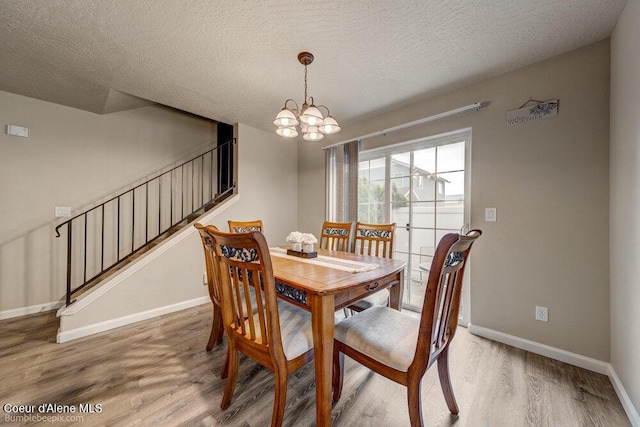 931 N Goldenrod Ct, Post Falls, ID 83854 - dining space featuring wood finished floors, stairs, a textured ceiling, and a chandelier