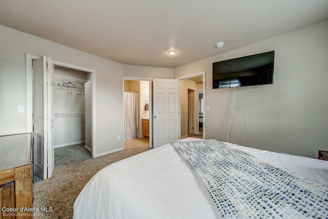 931 N Goldenrod Ct, Post Falls, ID 83854 - carpeted bedroom featuring a walk in closet, a closet, connected bathroom, and a textured ceiling