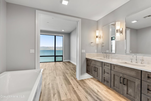 802 Sandpoint Ave # 8302, Sandpoint, ID 83864 - full bath with double vanity, a freestanding tub, wood finished floors, and a water view