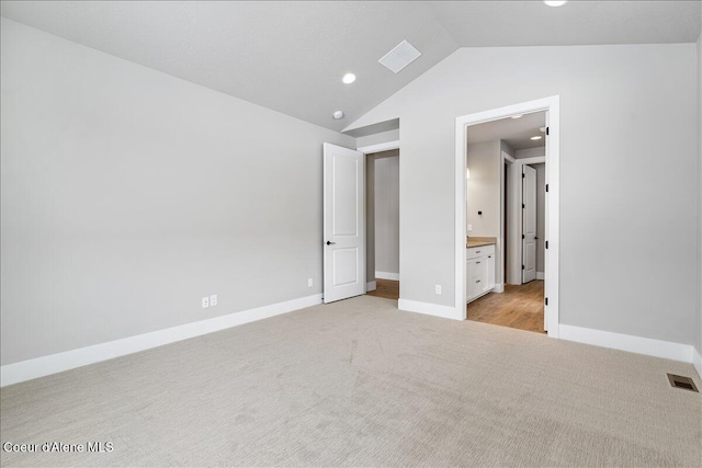 3510 N Cyprus Fox Loop, Post Falls, ID 83854 - unfurnished bedroom featuring light colored carpet, vaulted ceiling, recessed lighting, and connected bathroom