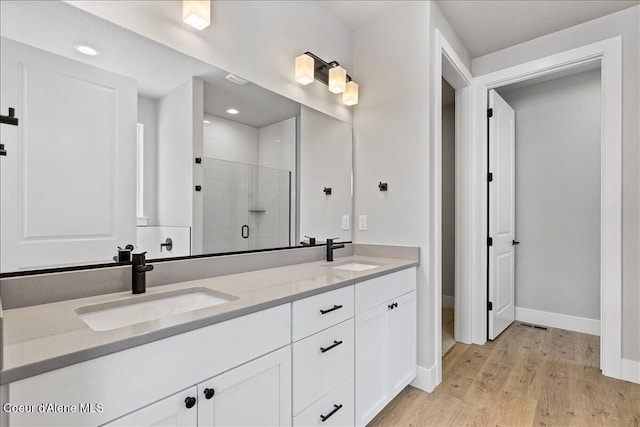 3510 N Cyprus Fox Loop, Post Falls, ID 83854 - full bathroom with a stall shower, double vanity, wood finished floors, and recessed lighting