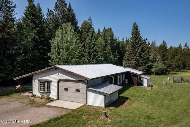 12 Otts Basin Rd, Sagle, ID 83860 - view of front of house featuring a front lawn, a garage, a forest view, an outbuilding, and a metal roof