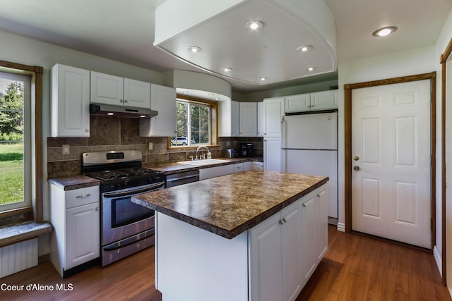 12 Otts Basin Rd, Sagle, ID 83860 - kitchen with appliances with stainless steel finishes, white cabinetry, dark countertops, under cabinet range hood, and decorative backsplash