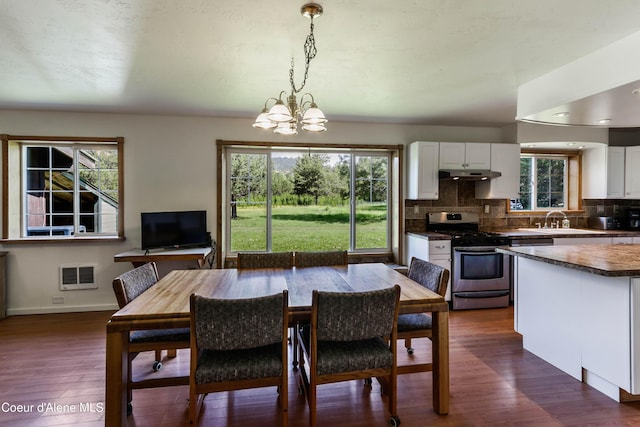 12 Otts Basin Rd, Sagle, ID 83860 - dining area featuring plenty of natural light, dark wood finished floors, heating unit, and a chandelier
