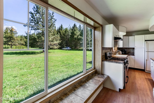 12 Otts Basin Rd, Sagle, ID 83860 - kitchen with freestanding refrigerator, gas stove, white cabinets, and plenty of natural light