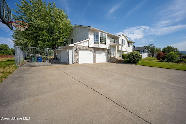 2442 N Rawhide Ridge Rd, Post Falls, ID 83854 - view of home's exterior featuring stone siding, an attached garage, a gate, and concrete driveway