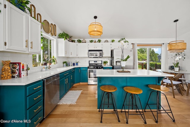 2442 N Rawhide Ridge Rd, Post Falls, ID 83854 - kitchen with stainless steel appliances, white cabinetry, backsplash, a breakfast bar area, and light countertops