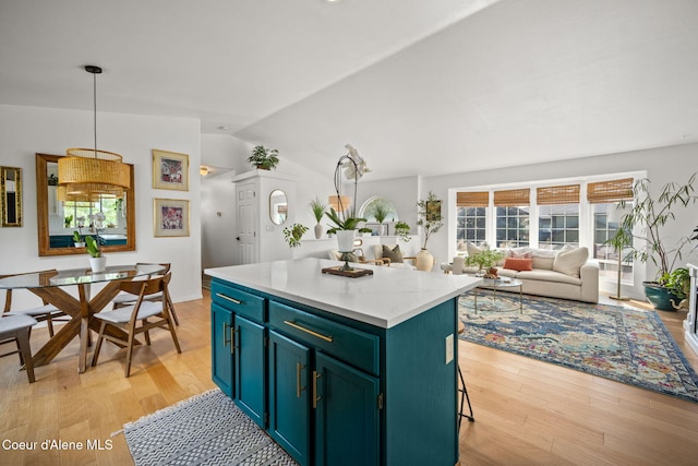 2442 N Rawhide Ridge Rd, Post Falls, ID 83854 - kitchen with light wood-style flooring, lofted ceiling, a kitchen island, light countertops, and decorative light fixtures