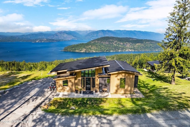1376 Less Traveled Rd, Sagle, ID 83860 - view of front of house featuring a water and mountain view, a patio area, and a front lawn