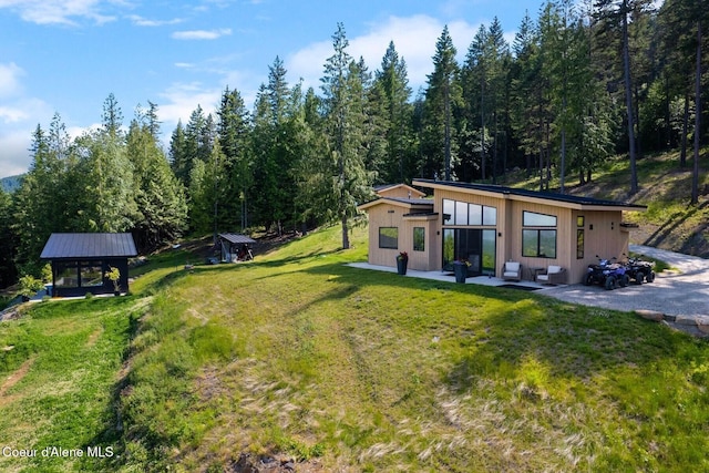 1376 Less Traveled Rd, Sagle, ID 83860 - view of grassy yard featuring a patio and a forest view
