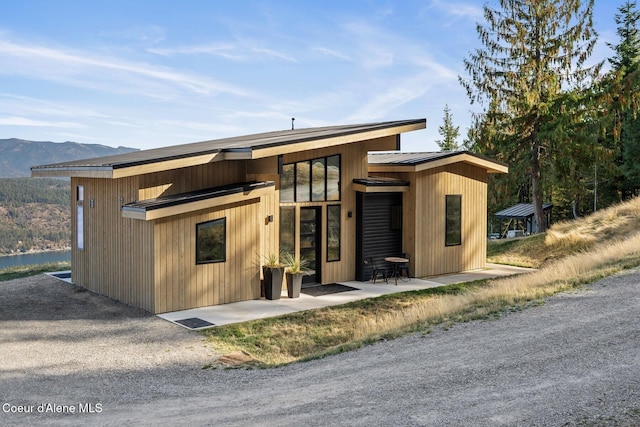 1376 Less Traveled Rd, Sagle, ID 83860 - rear view of house with a mountain view, a metal roof, and a patio area