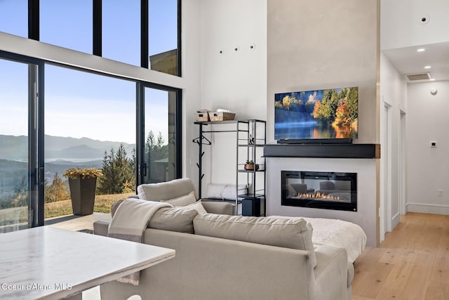 1376 Less Traveled Rd, Sagle, ID 83860 - living room with a towering ceiling, wood-type flooring, a glass covered fireplace, and recessed lighting