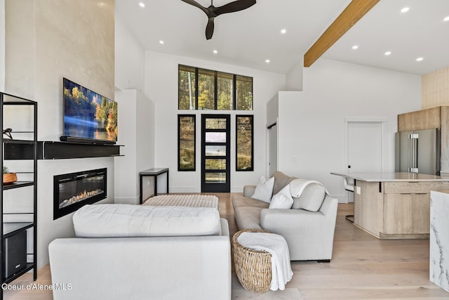 1376 Less Traveled Rd, Sagle, ID 83860 - living room featuring high vaulted ceiling, ceiling fan, beamed ceiling, light wood-type flooring, and a glass covered fireplace