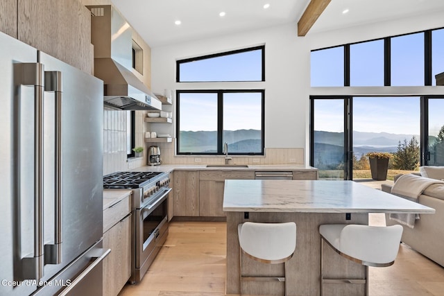1376 Less Traveled Rd, Sagle, ID 83860 - kitchen featuring appliances with stainless steel finishes, wall chimney range hood, modern cabinets, open shelves, and a mountain view