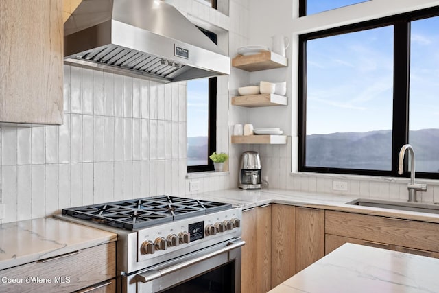 1376 Less Traveled Rd, Sagle, ID 83860 - kitchen with wall chimney range hood, stainless steel range with gas stovetop, backsplash, modern cabinets, and light stone counters