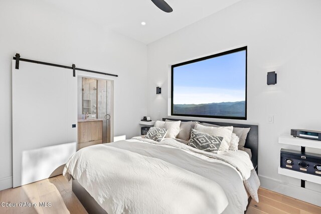 1376 Less Traveled Rd, Sagle, ID 83860 - bedroom featuring a barn door, wood finished floors, and a ceiling fan