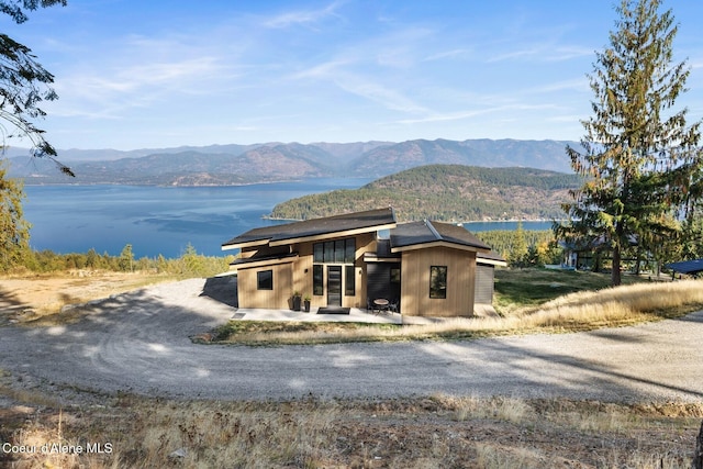 1376 Less Traveled Rd, Sagle, ID 83860 - view of front of home featuring driveway, a patio area, and a water and mountain view