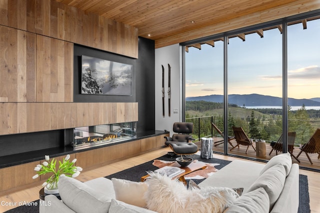5 Crystal Springs Ct, Sandpoint, ID 83864 - living room with a mountain view, wooden ceiling, a glass covered fireplace, wood finished floors, and expansive windows