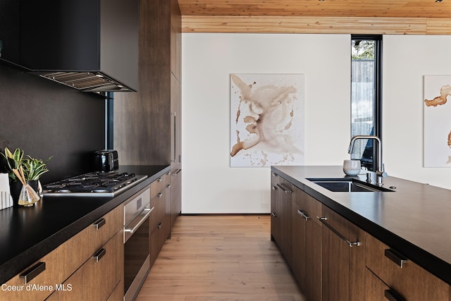 5 Crystal Springs Ct, Sandpoint, ID 83864 - kitchen with appliances with stainless steel finishes, dark countertops, wall chimney range hood, light wood finished floors, and wood ceiling