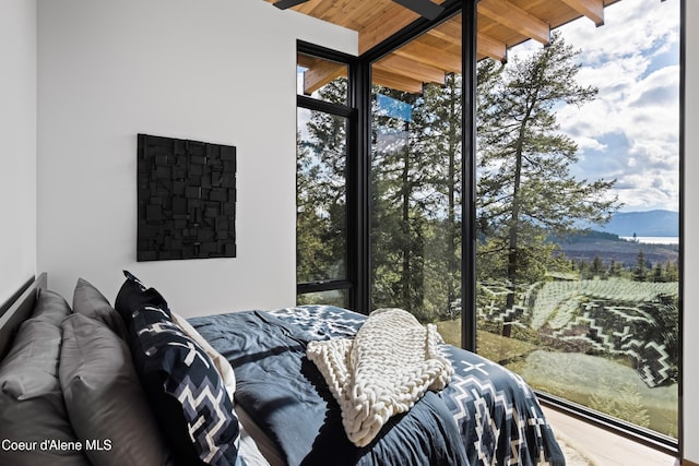 5 Crystal Springs Ct, Sandpoint, ID 83864 - bedroom with a wooden ceiling with exposed beams, a mountain view, wood finished floors, and a wall of windows