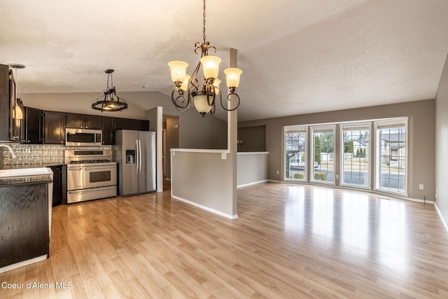 405 W 22nd Ave, Post Falls, ID 83854 - kitchen featuring stainless steel appliances, vaulted ceiling, light wood-style flooring, a chandelier, and pendant lighting