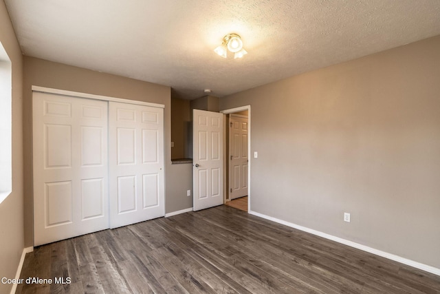 405 W 22nd Ave, Post Falls, ID 83854 - unfurnished bedroom with a closet, dark wood-style flooring, and a textured ceiling