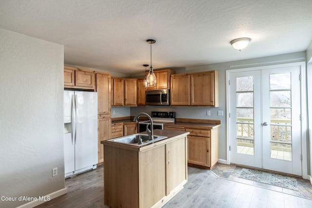 405 W 22nd Ave, Post Falls, ID 83854 - kitchen with white refrigerator with ice dispenser, stainless steel microwave, french doors, light wood-style flooring, and range