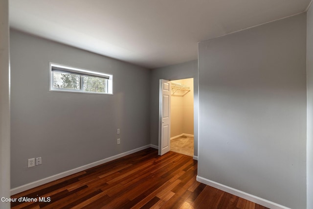 405 W 22nd Ave, Post Falls, ID 83854 - unfurnished bedroom with dark wood-style flooring, a closet, and a spacious closet
