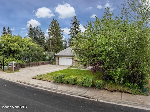 405 W 22nd Ave, Post Falls, ID 83854 - view of property hidden behind natural elements with driveway, brick siding, a garage, and view of wooded area