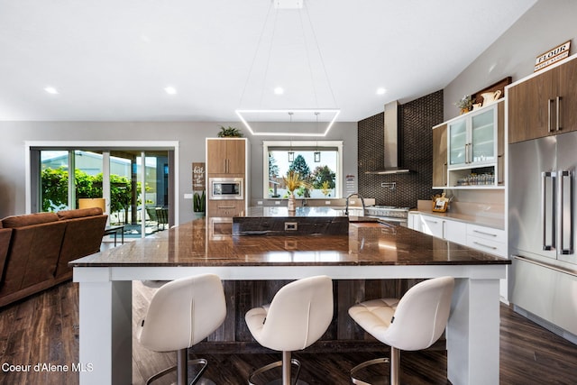 1222 W Tamarindo Ln, Hayden, ID 83835 - kitchen with stainless steel appliances, wall chimney range hood, modern cabinets, a breakfast bar area, and recessed lighting