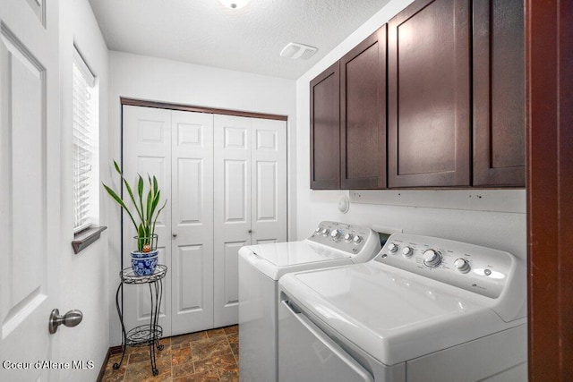 7090 N Epervier Ln, Coeur Dalene, ID 83815 - laundry room with cabinet space, washing machine and clothes dryer, dark stone finish flooring, and a textured ceiling