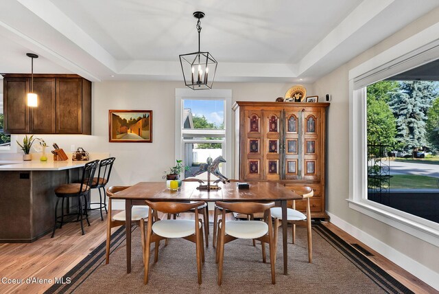 310 W Linden Ave, Coeur Dalene, ID 83814 - dining room with a tray ceiling, light wood finished floors, healthy amount of natural light, and a chandelier
