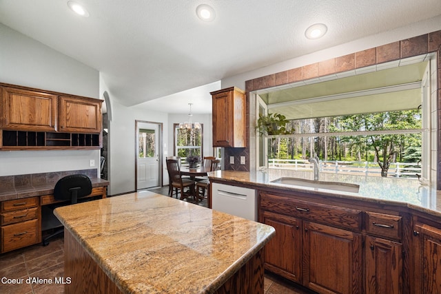 699 W Ranch Ct, Rathdrum, ID 83858 - kitchen featuring a kitchen island, backsplash, built in desk, vaulted ceiling, and recessed lighting