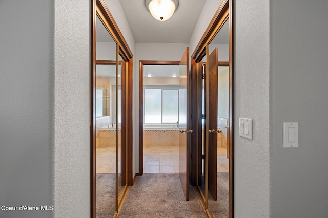 699 W Ranch Ct, Rathdrum, ID 83858 - corridor with carpet floors, a textured wall, and tile patterned flooring
