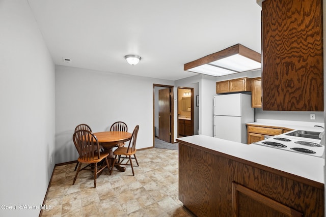 699 W Ranch Ct, Rathdrum, ID 83858 - kitchen with freestanding refrigerator, light countertops, a peninsula, cooktop, and light flooring