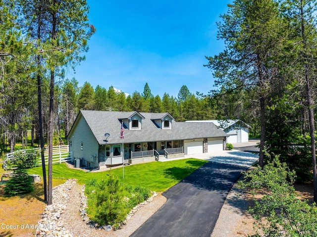 699 W Ranch Ct, Rathdrum, ID 83858 - cape cod house featuring covered porch, an attached garage, and asphalt driveway