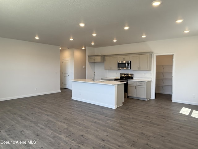 5103 E Rigel Ln, Post Falls, ID 83854 - kitchen featuring stainless steel microwave, range with electric cooktop, dark wood finished floors, an island with sink, and gray cabinetry