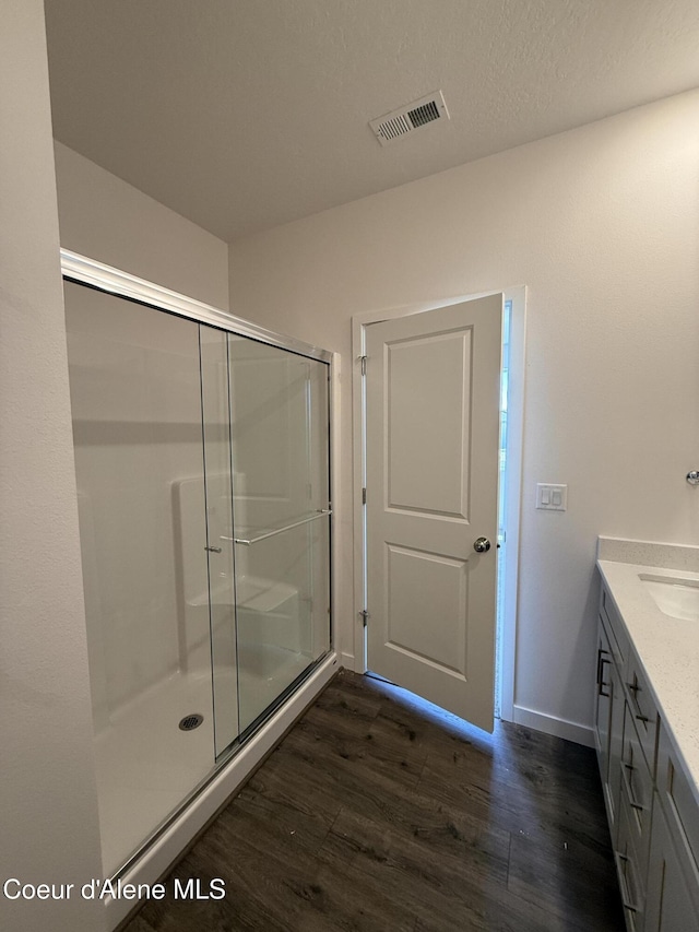 5103 E Rigel Ln, Post Falls, ID 83854 - full bathroom with wood finished floors, vanity, and a stall shower