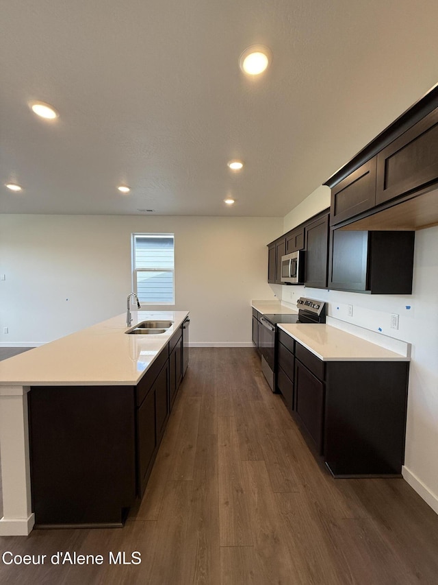 5149 E Rigel Ln, Post Falls, ID 83854 - kitchen with stainless steel appliances, dark wood-style floors, an island with sink, recessed lighting, and light countertops