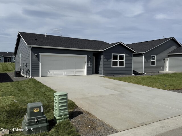 5149 E Rigel Ln, Post Falls, ID 83854 - ranch-style house with driveway, a garage, a front lawn, and roof with shingles