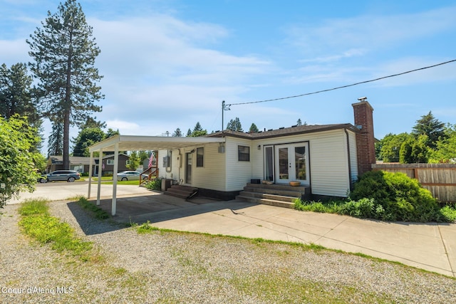 1623 E Boyd Ave, Coeur Dalene, ID 83814 - rear view of house with entry steps, french doors, driveway, a carport, and a chimney