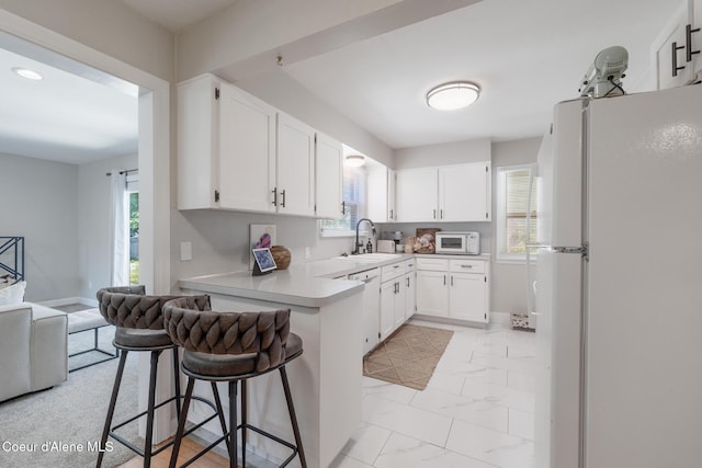 1623 E Boyd Ave, Coeur Dalene, ID 83814 - kitchen with white appliances, plenty of natural light, light marble finish flooring, a kitchen bar, and recessed lighting