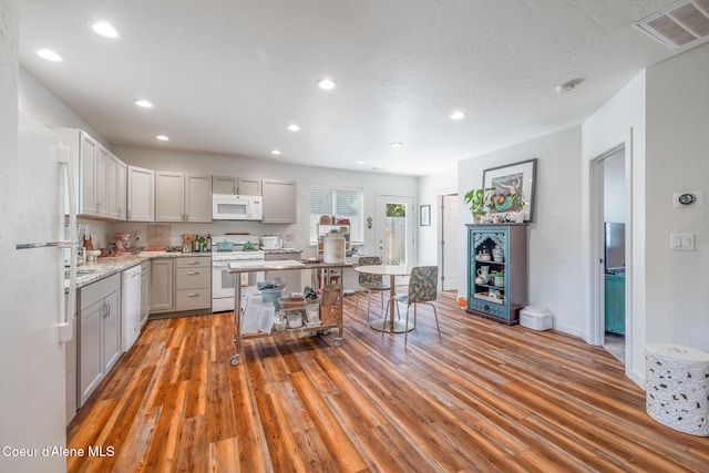 1623 E Boyd Ave, Coeur Dalene, ID 83814 - kitchen featuring white appliances, light wood-type flooring, recessed lighting, gray cabinets, and light stone countertops