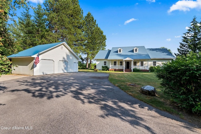 182 Sunnyside Rd, Sandpoint, ID 83864 - view of front facade featuring a porch, an outbuilding, a garage, and a metal roof